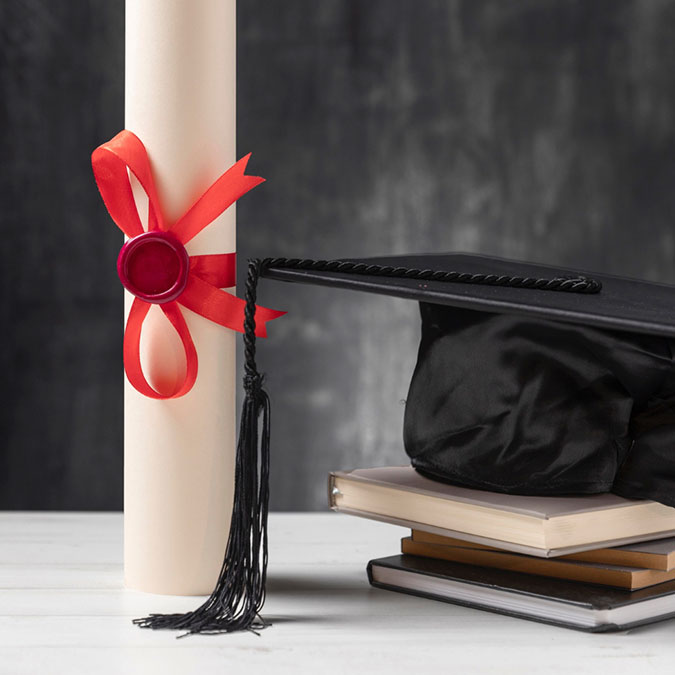 Diploma, doctor hat and some books on a table
